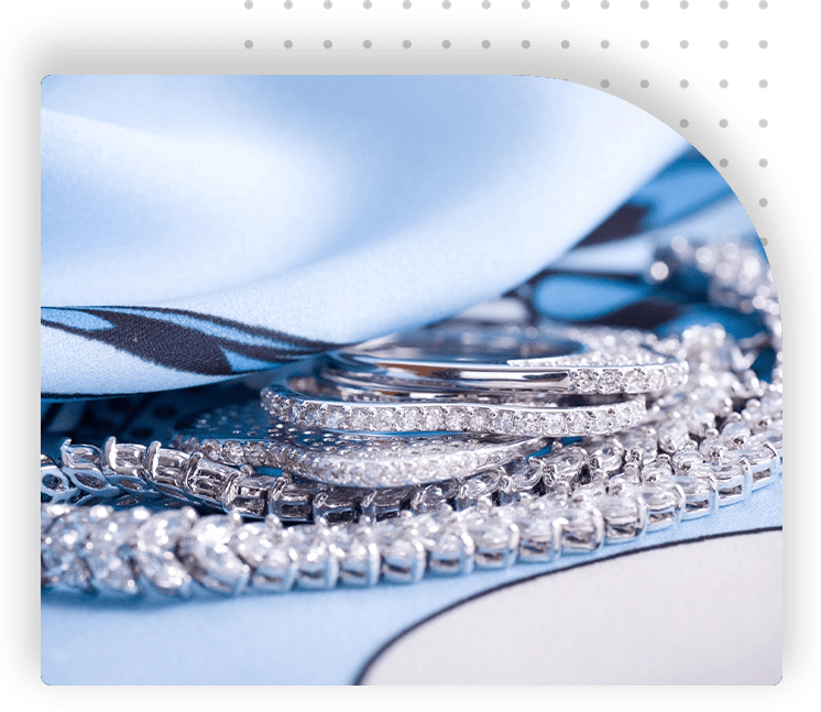 A close up of some silver jewelry on top of a table.