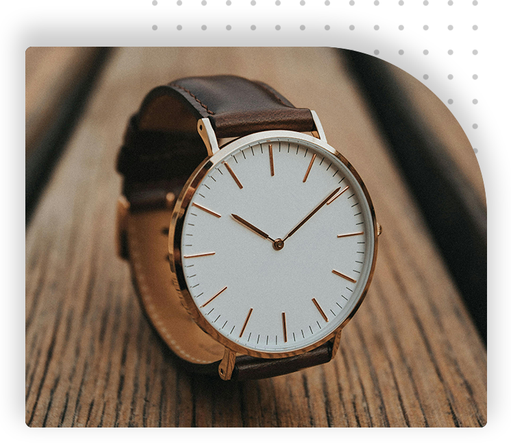 A watch is sitting on top of a wooden table.