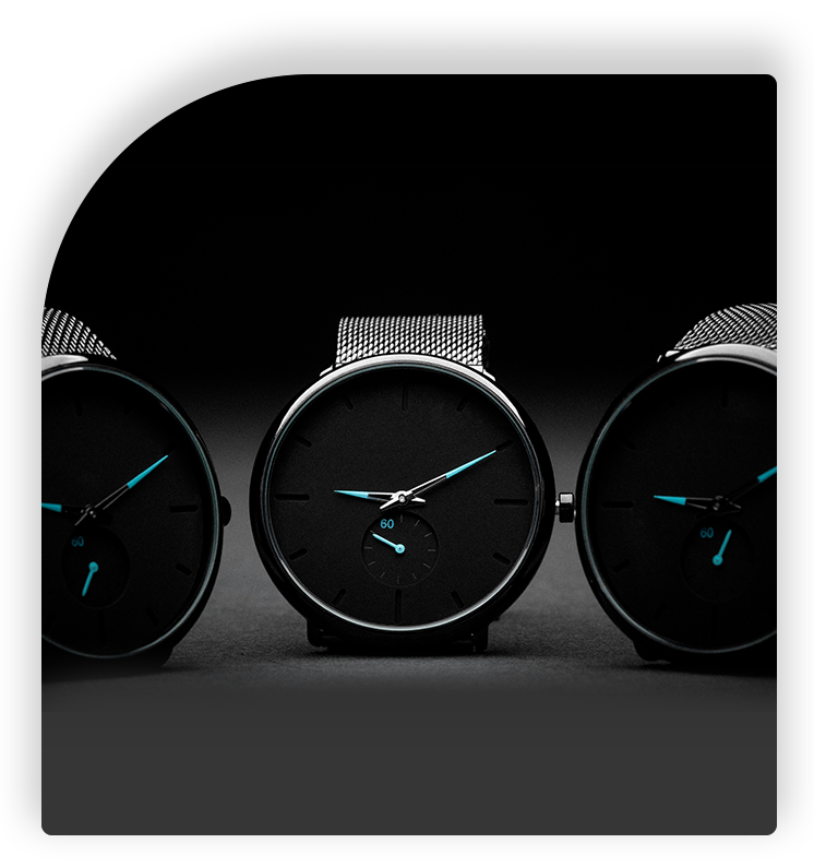 Three black watches with blue hands on a table.