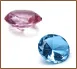 A pink and blue diamond are sitting next to each other.